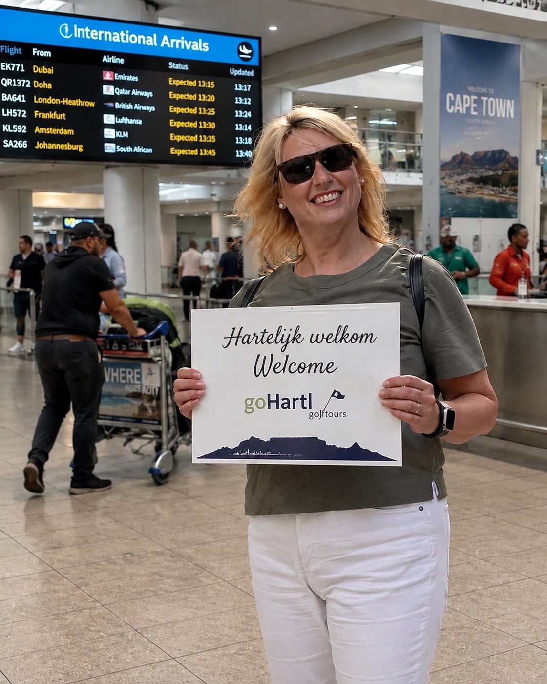 Mari Wagner in de aankomsthal van de luchthaven van Kaapstad, met het bord ‘Hartelijk welkom’